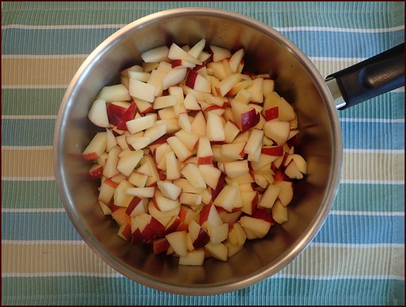 Apples cut into pieces in large saucepan.