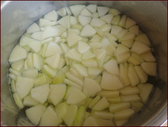 Apple slices dropped into boiled water.