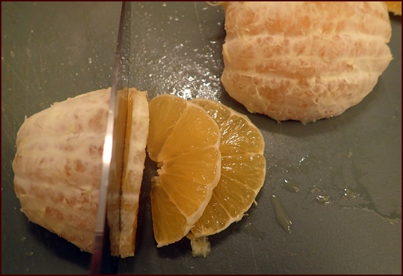 Cutting half of a peeled orange.