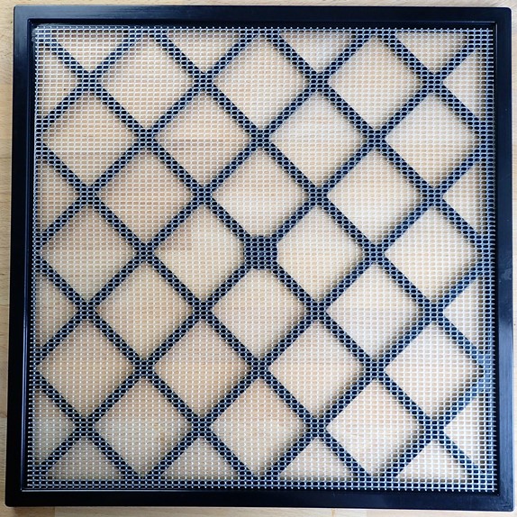 Excalibur dehydrator tray has rigid plastic framework with flexible mesh sheets that sit on top. Size: 15" x 15" = 225 square inches.