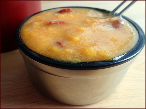 Photo shows one of two servings of an Orange-Mango Spoon Smoothie with raspberries.