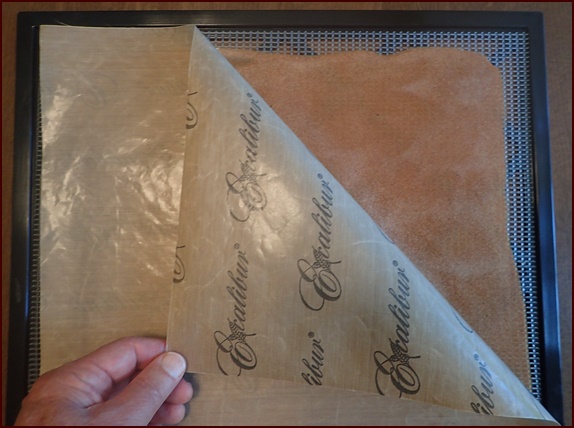 Flip the apple fruit leather over and peel off nonstick sheet.