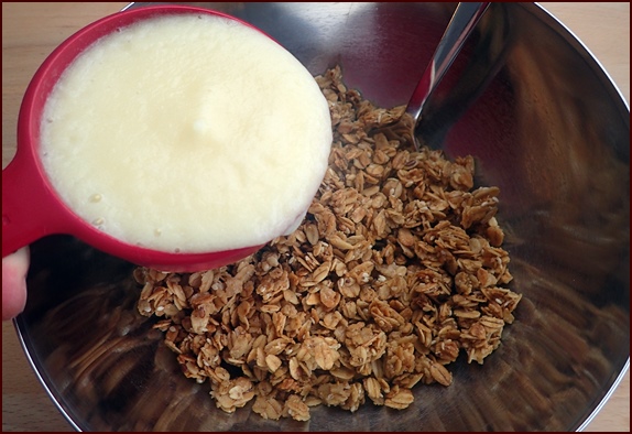 Combining blended pineapple with granola to make clusters.