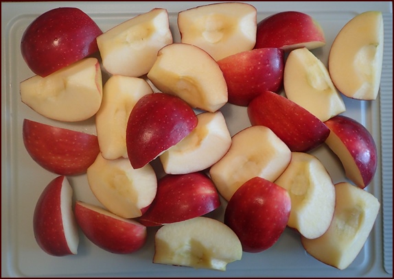 Six apples cut into quarters with cores cut out.