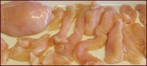 Cutting chicken breast meat for tenderizing and pressure cooking.