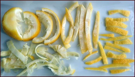 Cutting citrus peels for drying. Cut away the white pithy part.