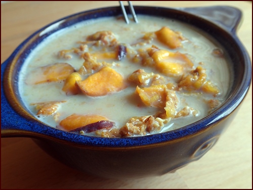 A healthy bowl of peach crunch breakfast with milk.