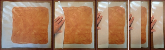Folding apple fruit leather in parchment paper.