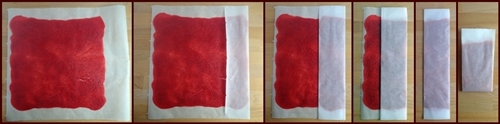 Folding dehydrated fruit leather in parchment paper.