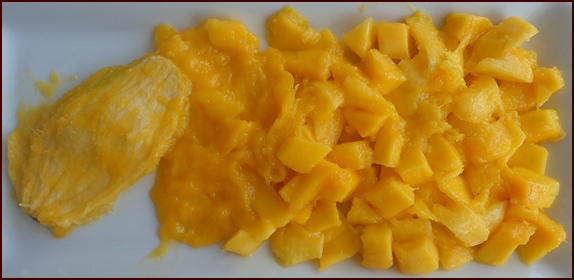 Photo shows a mango after cutting it into smaller pieces, including scrapings off the pit and from the underside of the skin.